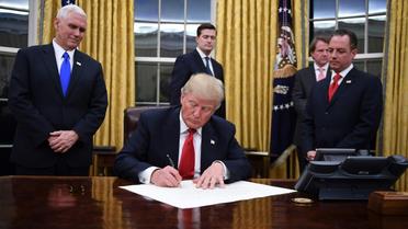 Donald Trump signe ses premiers décrets en qualité de président des Etats-Unis, le 20 janvier 2017 [JIM WATSON / AFP]