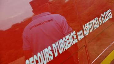 Gendarme se reflétant sur la carosserie d'une ambulance des pompiers [Thierry Zoccolan / AFP/Archives]