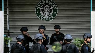 Des policiers indonésiens devant le café initialement visé par les terroristes à Jakarta, le 16 janvier 2016 [MANAN VATSYAYANA / AFP]