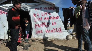 Des migrants dans le camp d'Idomeni en Grèce, le 26 mars 2016, à proximité de la frontière avec la Macédoine [SAKIS MITROLIDIS / AFP]