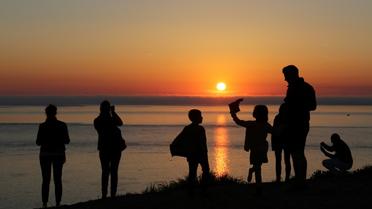 Une famille regarde le coucher du soleil au sommet de la dune du Pyla au Pyla-sur-Mer (Gironde), le 9 avril 2017  [LUDOVIC MARIN / AFP/Archives]