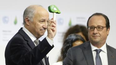 Le président de la COP21 Laurent Fabius donne un coup de marteau symbolique pour marquer l'officialisation de l'accord sur le climat, au côté du président français François Hollande, le 12 décembre 2015 au Bourget [FRANCOIS GUILLOT / AFP]