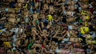 Des détenus dorment les uns sur les autres sur le terrain de basket de la prison surpeuplée de Quezon City, à Manille, le 19 juillet 2016 [NOEL CELIS / AFP]
