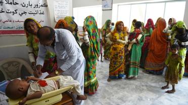 Un médecin vérifie le poids d'un enfant à l'hôpital pakistanais de Mithi, le 25 mai 2018 [RIZWAN TABASSUM / AFP]