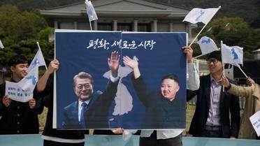 Les photos du président sud-coréen Moon Jae-in (g) et du leader nord-coréen Kim Jong-Un lors d'un rassemblement pour la paix, le 26 avril 2018 à Séoul [Ed JONES / AFP]