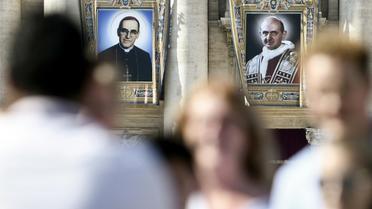 Portraits de l'archevêque salvadorien Oscar Romero (g) et du pape Paul VI (d) sur la façade de la Basilique Saint-Pierre, au Vatican, le 13 octobre 2018 [Filippo MONTEFORTE / AFP]