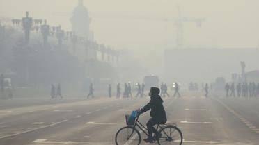 Un cycliste sous un nuage de pollution à Pékin, le 21 décembre 2015 [WANG ZHAO / AFP/Archives]