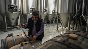 Le microbrasseur Sophocle Panagiotou remplit un verre d'une bière qu'il produit, le 28 février 2019 sur l'île d'Eubée en Grèce [ARIS MESSINIS / AFP]