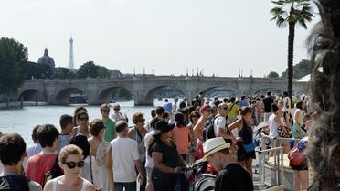 Des personnes se promènent sur les bords de la Seine, lors de la 12e édition de Paris-Plages, le 20 juillet 2013 [Miguel Medina / AFP/Archives]