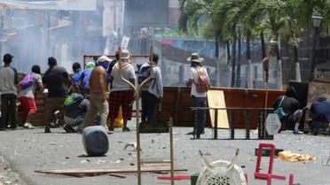 Des manifestants s'abritent derrière des barricades de fortune lors de heurts avec les forces de police, le 2 juin 2018 à Monimbo, près de Masaya, à 40 km de Managua, au Nicaragua [INTI OCON / AFP]
