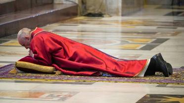 Le pape François prosterné en prière sur le sol avant de présider l’office de la Passion en la basilique Saint-Pierre lors du Vendredi saint, le 10 avril 2020 au Vatican  [Andrew Medichini / POOL/AFP]