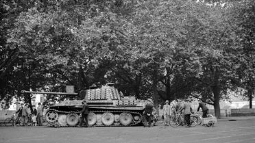 Des badauds découvrent un char panther abandonné par les Allemands sur les quais de la Seine, entre le Pont Neuf et le Pont Notre-Dame, aux alentours du 19 août, quelques jours avant la Libération de Paris, le 25 août 1944 [ / AFP/Archives]