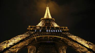 "1,5 degré" est inscrit en néon blanc sur la Tour Eiffel, le 10 décembre 2015 la veille de la clôture de la COP21 [PATRICK KOVARIK / AFP]