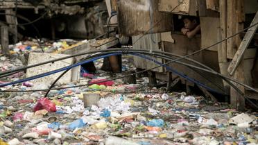 Un ruisseau rempli de plastiques dans un bidonville de Manille le 12 mai 2018. [NOEL CELIS / AFP/Archives]
