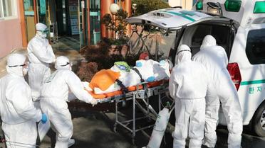 Le personnel médical transfère un patient soupçonné d'être porteur du coronavirus de l'hôpital Daenam à Cheongdo le 21 février 2020 [- / YONHAP/AFP]