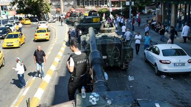 Un policier turc juché sur un tank à Istanbul, le 16 juillet 2016 [BULENT KILIC / AFP]