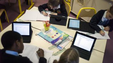Des élèves étudient avec des tablettes numériques en France [Fred Dufour / AFP/Archives]