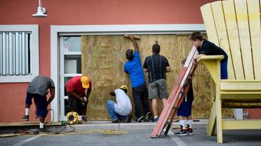 Des habitants de Panama City, en Floride, protègent la vitrine d'une pizzeria à l'approche de l'ouragan Michael, le 9 octobre 2018 [Brendan Smialowski / AFP]