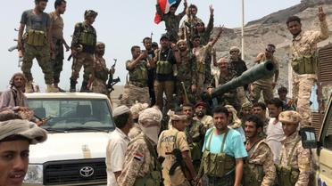 Des séparatistes du sud du Yémen posent devant un char confisqué sur une base militaire gouvernementale à Aden, le 10 août 2019 [Nabil HASAN / AFP]