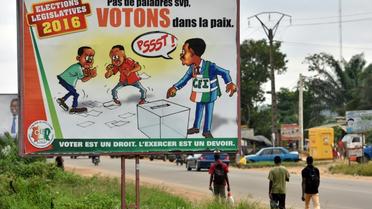 Une affiche de la Commission électorale indépendante, dans les rues d'Abidjan, le 17 décembre 2016 [Sia KAMBOU / AFP]