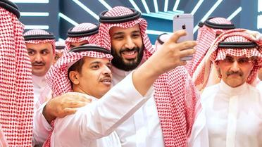 Le prince héritier d'Arabie saoudite Mohammed ben Salmane pose pour une photo avec un participant du forum Future Investment Initiative (FII) à Ryad, le 23 octobre 2018. [Bandar AL-JALOUD / Saudi Royal Palace/AFP]