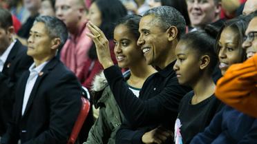 Barack Obama entouré par ses filles Malia (g) et Sasha (d), lors d'un match de basket dans le Maryland, le 17 novembre 2013 [Drew Angerer / Getty Images/AFP/Archives]