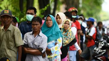 Des habitants de la zone touchée par le séisme et le tsunami font la queue pour recevoir une aide, le 4 octobre 2018 à Palu, en Indonésie [JEWEL SAMAD / AFP]
