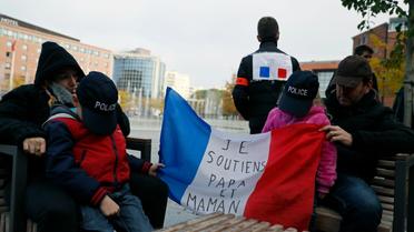 Des enfants de policiers tiennent une banderole soutenant leurs parents "je soutiens papa et maman" lors d'une manifestation de policiers, le 22 octobre à Evry [Thomas SAMSON / AFP]