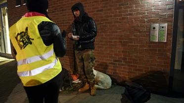 Une volontaire des Restos du Coeur apporte un repas à un sans-abri à Strasbourg, où la température est descendue à -7 degrés en soirée le 26 février 2018 [FREDERICK FLORIN / AFP]