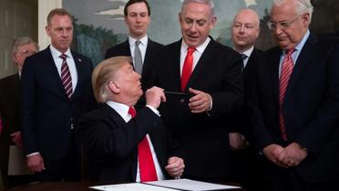 Donald Trump tend son stylo au Premier ministre israélien Benjamin Netanyahu après avoir signé le décret reconnaissant officiellement la souveraineté d'Israël sur le plateau du Golan, le 25 mars 2019 à Washington [SAUL LOEB / AFP]