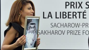 Raef Badaoui tient un portrait de son époux Ensaf Haidar, blogueur saoudien emprisonné, lors de la remise du prix Sakharov à son mari, le 16 décembre 2015 [PATRICK HERTZOG / AFP]