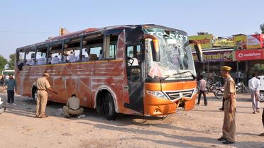 Des policiers indiens inspectent le bus accidenté qui transportait des touristes français en Inde, le 14 octobre 2013 [ / AFP]