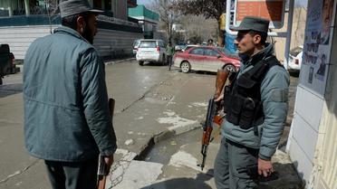 Deux policiers afghans sur le lieu du meurtre d'un journaliste anglo-suédois à Kaboul le 11 mars 2014 [Shah Marai / AFP]