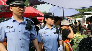 Des policiers patrouillent dans un marché à Urumqi, le 23 mai 2014, au lendemain d'un attentat  [ / AFP]