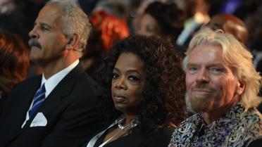 Le milliardaire Richard Branson (d) en compagnie de la présentatrice vedette américaine Oprah Winfrey aux funérailles de Nelson Mandela à Qunu, en Afrique du Sud, le 15 décembre 2013 [Odd Andersen / Pool/AFP/Archives]