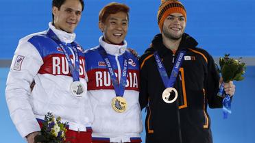 Ahn Hyun-soo (c), un Sud-Coréen naturalisé Russe, sourit sur le podium après sa victoire en short-track, le 15 février 2014 à Sotchi [Adrian Dennis / AFP]