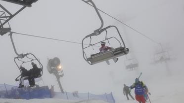 Des sportifs et des spectateurs dans le parc Extrême de Rosa Khoutor, près de Sotchi, après le report de l'épreuve du snowboardcross messieurs en raison du brouillard persistant, le 17 janvier 2014 [Javier Soriano / AFP]
