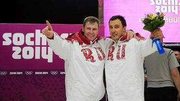 Alexander Zubkov (G) et Alexey Voevoda (D) lors de la cérémonie de la remise de bouquets après leur victoire en bobsleigh à deux, le 17 février à Rosa Khoutor [ / AFP]