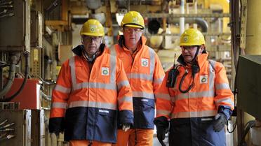 Le Premier ministre britannique James Cameron (c) visite, le 24 février 2014, une plateforme BP en mer du Nord, avec des responsables de la société, Trevor Garlick (g) et Mark Furness (d) [Andy Buchanan / Pool/AFP]