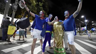 Des supporteurs français fêtent la victoire des Bleus contre la Suisse (5-2) avec une réplique géante de la Coupe du monde, à Salvador, le 20 juin 2014 [Franck Fife / AFP]