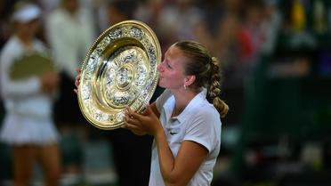 La Tchèque Petra Kvitova soulève le trophée de vainqueur du tournoi de Wimbledon, samedi 5 juillet 2014, après sa victoire en finale contre la Canadienne Eugénie Bouchard en finale, 6-3, 6-0. [Carl Court / AFP]