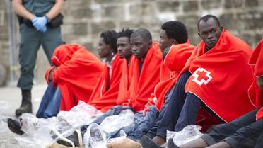 Des candidats à l'immigration se reposent au port de Tarifa après avoir été secourus au large des côtes espagnoles le 11 août 2014 [Marcos Moreno / AFP]