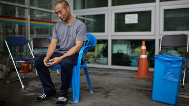 Un homme dont la fille se trouvait à bord du ferry qui a fait naufrage, attend  le 7 juillet 2014 devant le gymnase de Jindo  [Ed Jones / AFP]