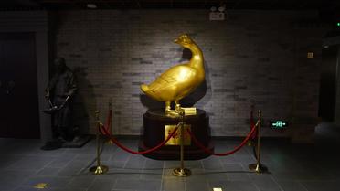 Un canard en or trône le 24 juillet 2014 dans l'entrée du musée de l'enseigne Quanjude à Pékin consacré au canard laqué  [Greg Baker / AFP]