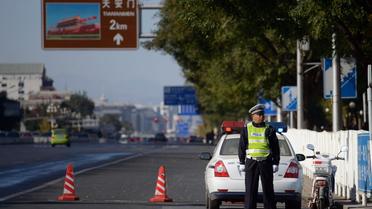 Un policier surveille l'avenue Chang'an aux abords de la place Tiananmen à Pékin, le 29 octobre 2013 [Ed Jones / AFP]