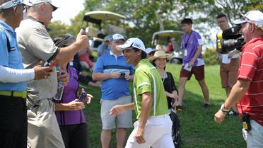 Le golfeur chilien Felipe Aguilar (c) est applaudi par les spectateurs après avoir réalisé un eagle lors du dernier trou pour s'adjuger le titre de l'Open de Singapour, le 4 mai 2014 [ / AFP]