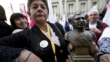 Une partisane d'Evelyn Matthei à la présidentielle, le 18 août 2013 à Santiago, tient un buste d'Augusto Pinochet [Martin Bernetti / AFP]