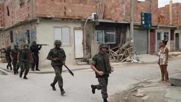 Des soldats à la recherche d'armes dans l'ensemble de favelas de Maré, situé dans la banlieue nord de Rio de Janeiro, le 26 mars 2014 [Christophe Simon / AFP/Archives]