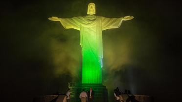 Le Christ Rédempteur s'illumine alternativement aux couleurs des 32 pays engagés, le 11 juin 2014 au dessus de la baie de de Rio de Janeiro [Yasuyoshi Chiba / AFP]