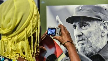 Une femme devant une photo du président cubain Fidel Castro, le 12 août 2014 à La Havane [Adalberto Roque / AFP]